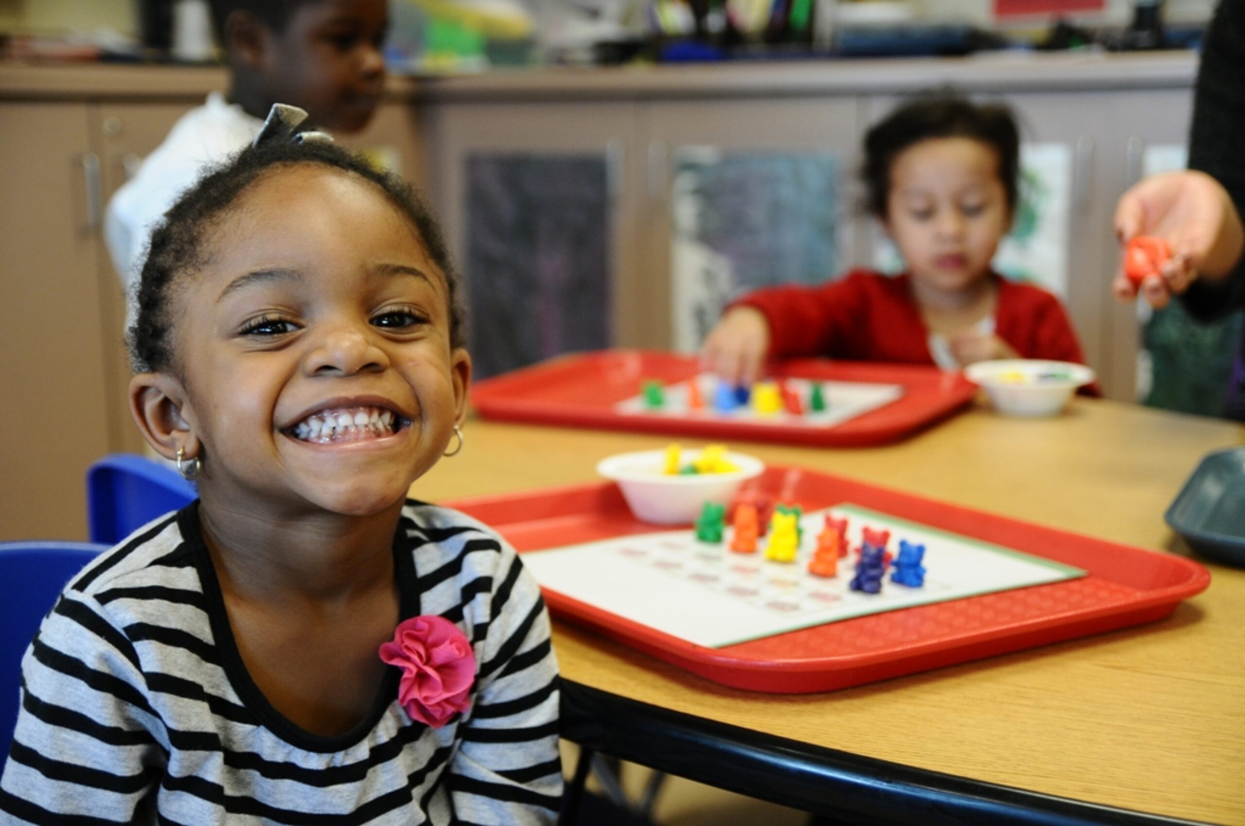 A smiling child taking part in an activity at preschool